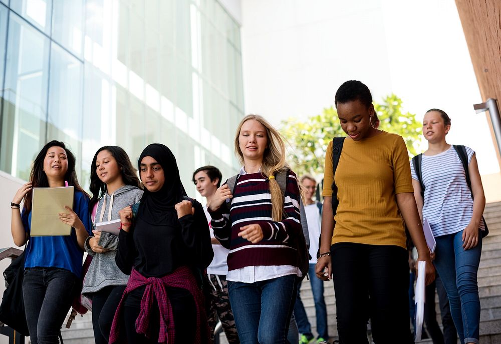 Diverse group of students walking in school 