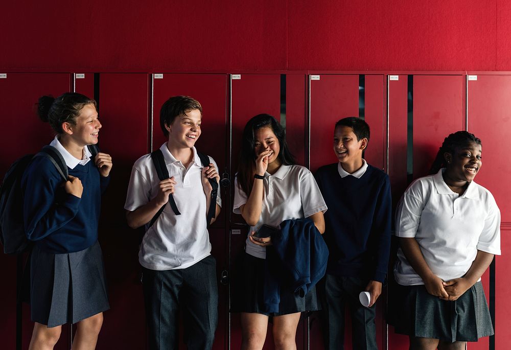 Friends standing together in front of lockers