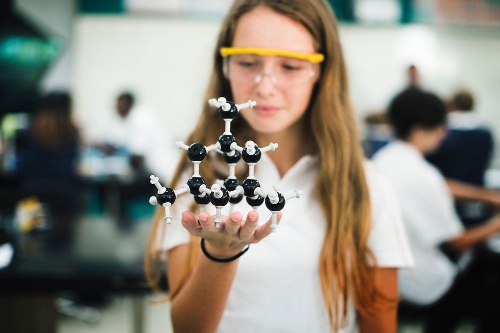 High school student hand holding molecul structure in chemistry class