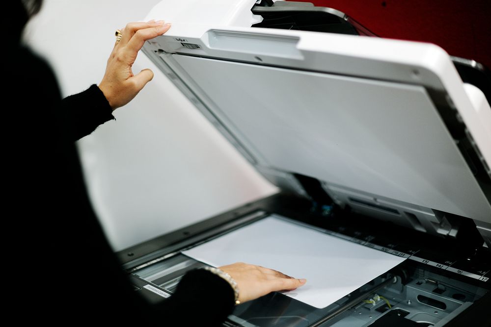 Woman using machine to copy document