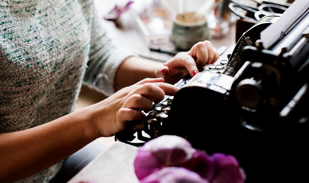 Closeup of hands typing classic retro typewriter