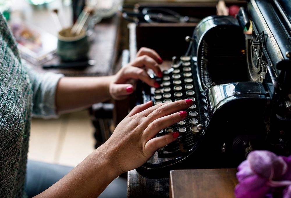 Closeup of hands typing classic retro typewriter
