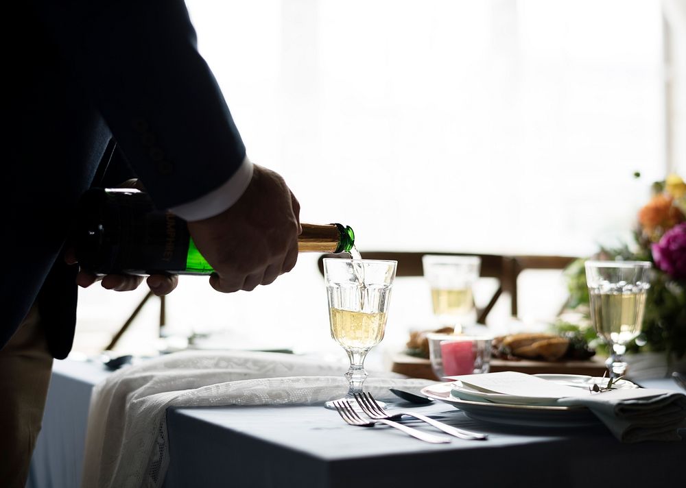 Hand Pouring Filling Champagne Drink to Glasses