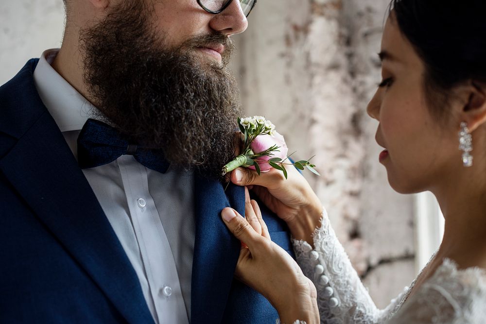 Bride Put on Small Flower Bouqet on Groom Tuxedo