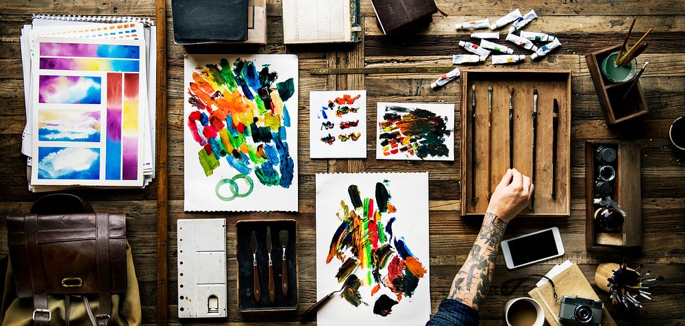 Hands with tattoo painting a abstract artwork