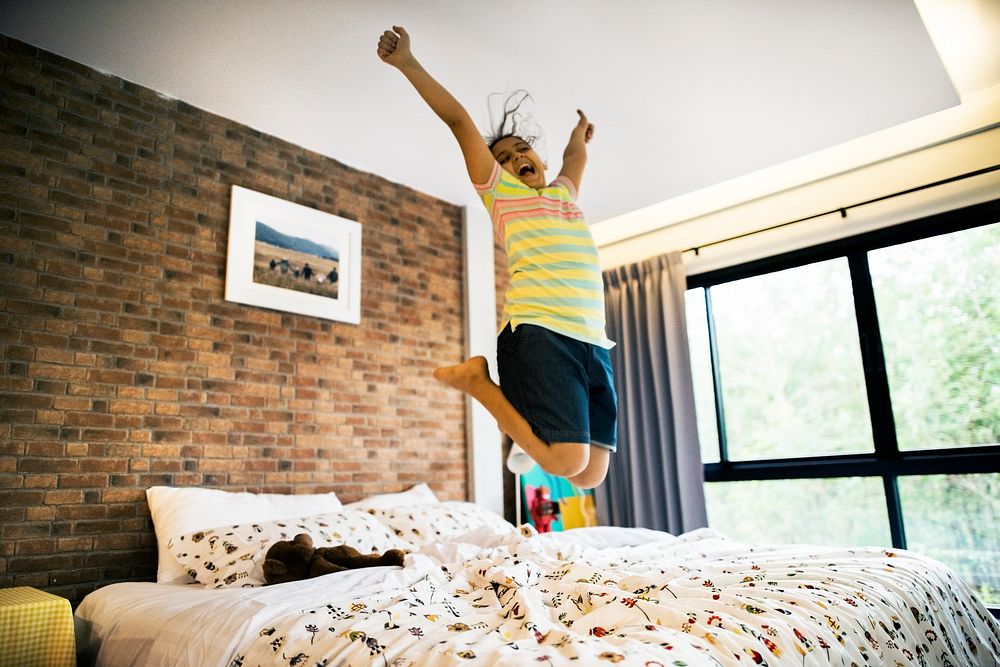 Young girl jumping on the bed
