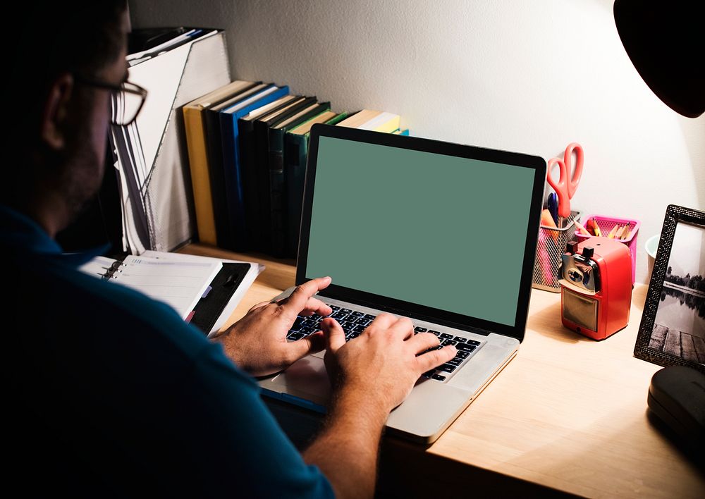 Man working in a home office with a laptop