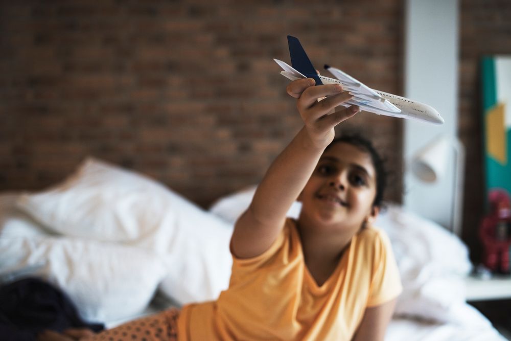 Young girl playing with airplane toy