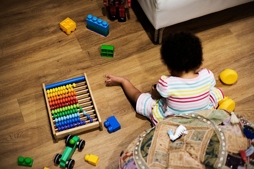 Little girl playing with building blocks on the floor