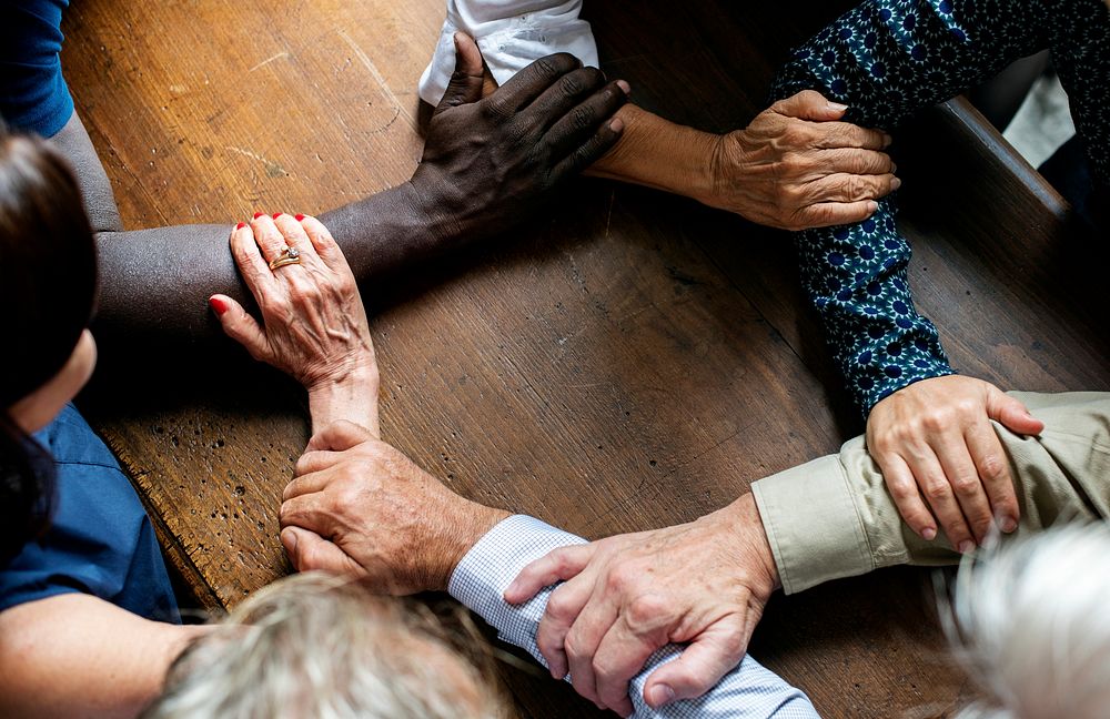 Group of diverse hands holding each other forearms 