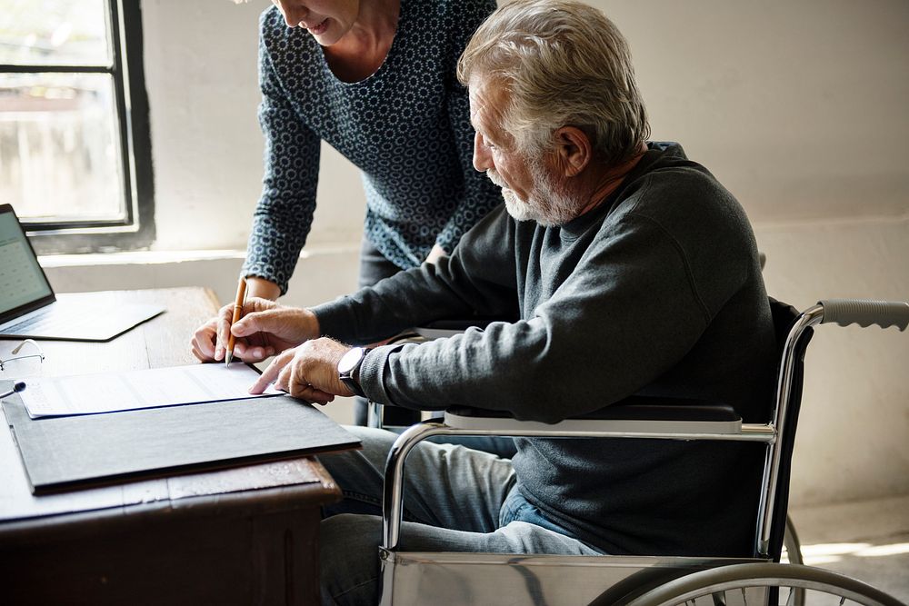Side view of elderly man completing documents