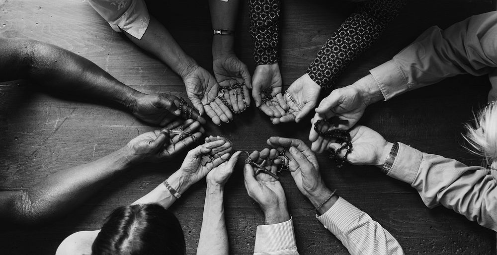 Group of diverse hands palms circle support together teamwork aerial view grayscale