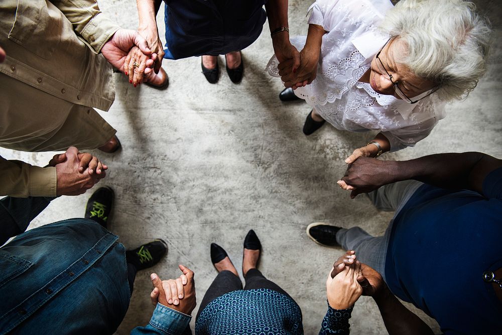 Group of diverse hands holding each other support together teamwork aerial view