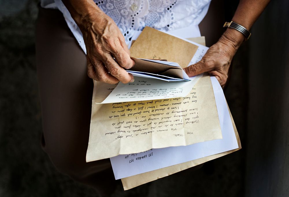 Elderly woman holding old letters in her hands