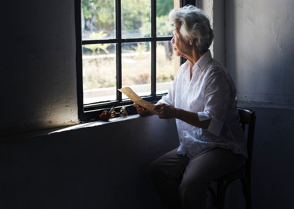 Elderly asian woman with a letter in her hands