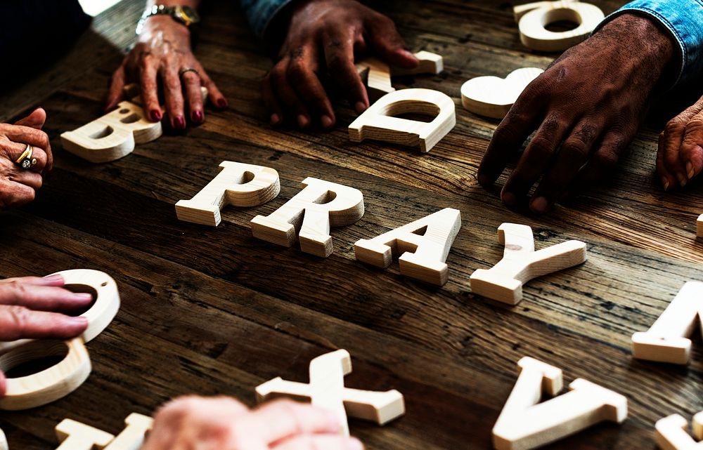 Group of people arrangement a word on wooden table