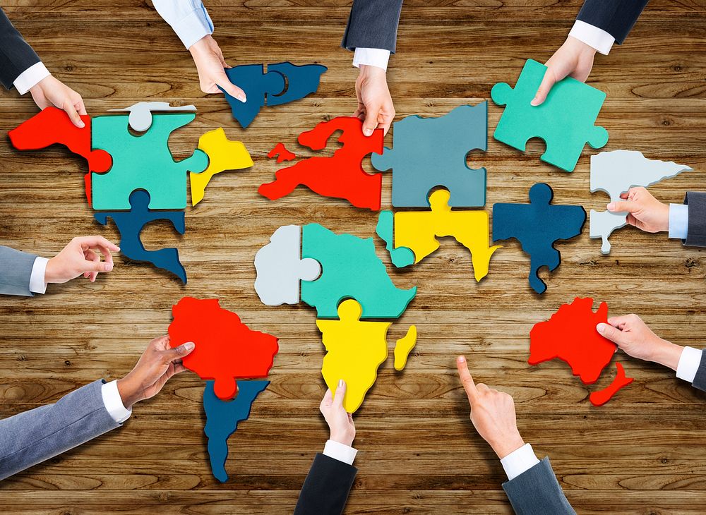 Business People Forming World Map with Puzzle Pieces