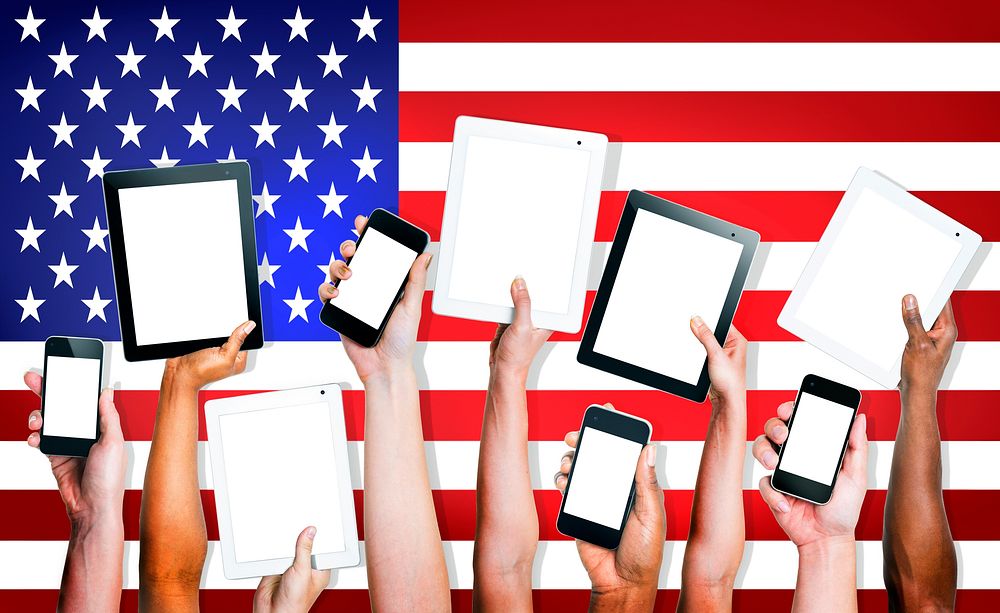 Group of People's Hands Holding Digital Tablets and Mobile Phones with American Flag on the Background