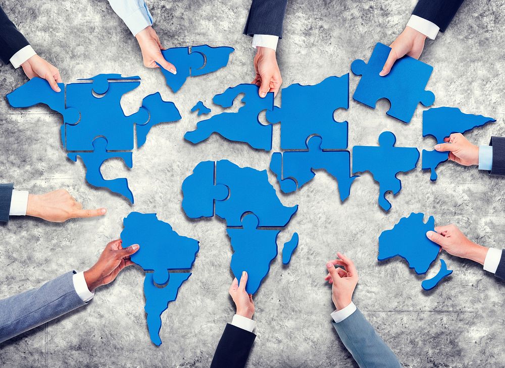 Group of Business People with Jigsaw Puzzle Forming in World Map