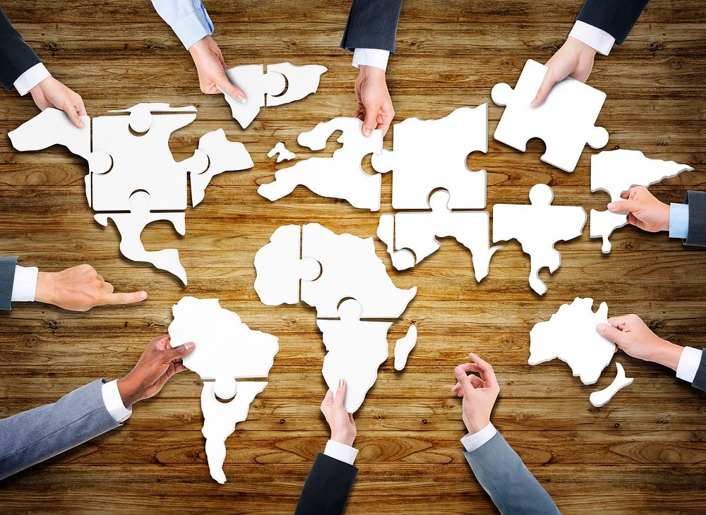 Group of Business People with Jigsaw Puzzle Forming in World Map