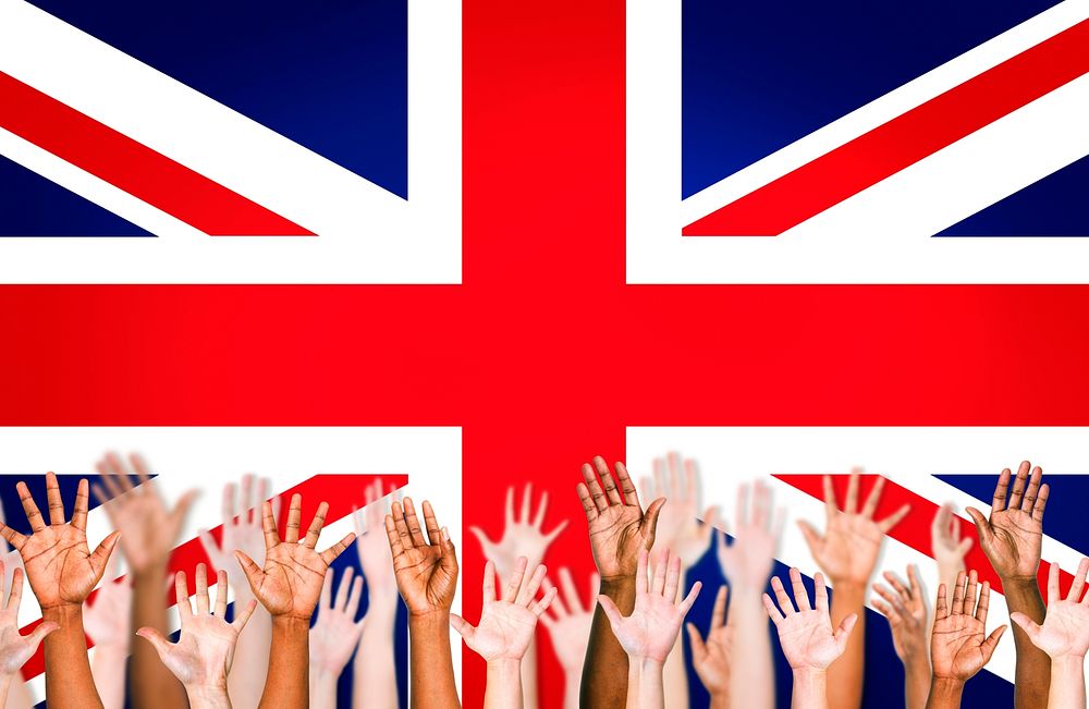 Multi-Ethnic Hands Raised With British Flag As A Background