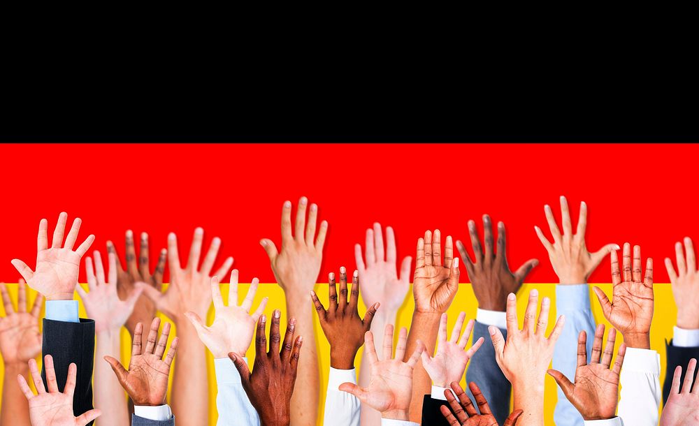 Multi-Ethnic Hands Raised and German Flag Background