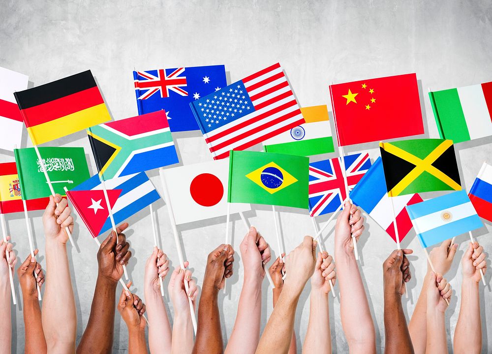 Group of hands holding national flags.