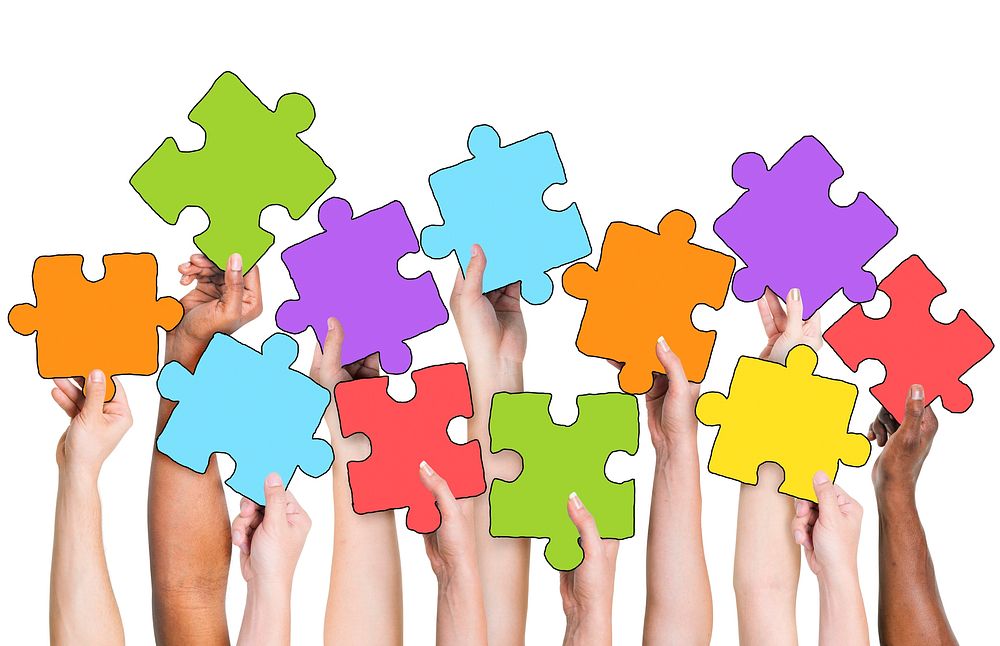 Human Hand Holding Colorful Jigsaw Puzzle Pieces