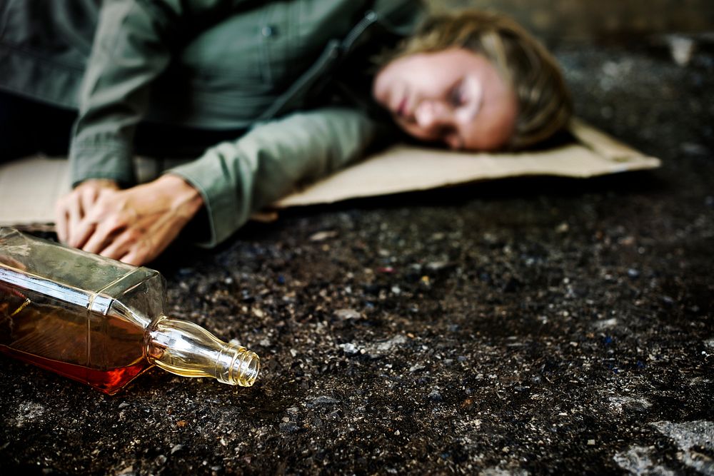 Homeless woman with an alcohol bottle