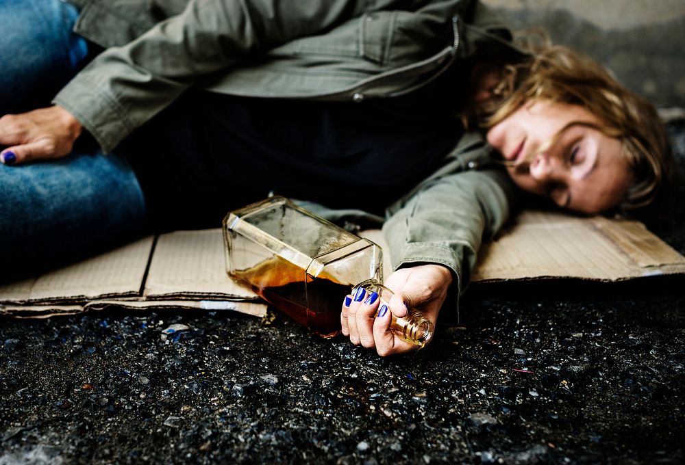 Drunk woman beggar sleeping on a dirty street