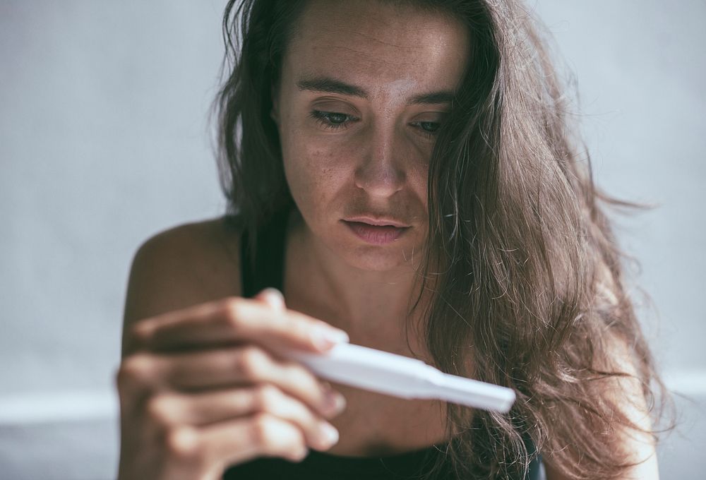 Depressed woman holding a pregnancy test