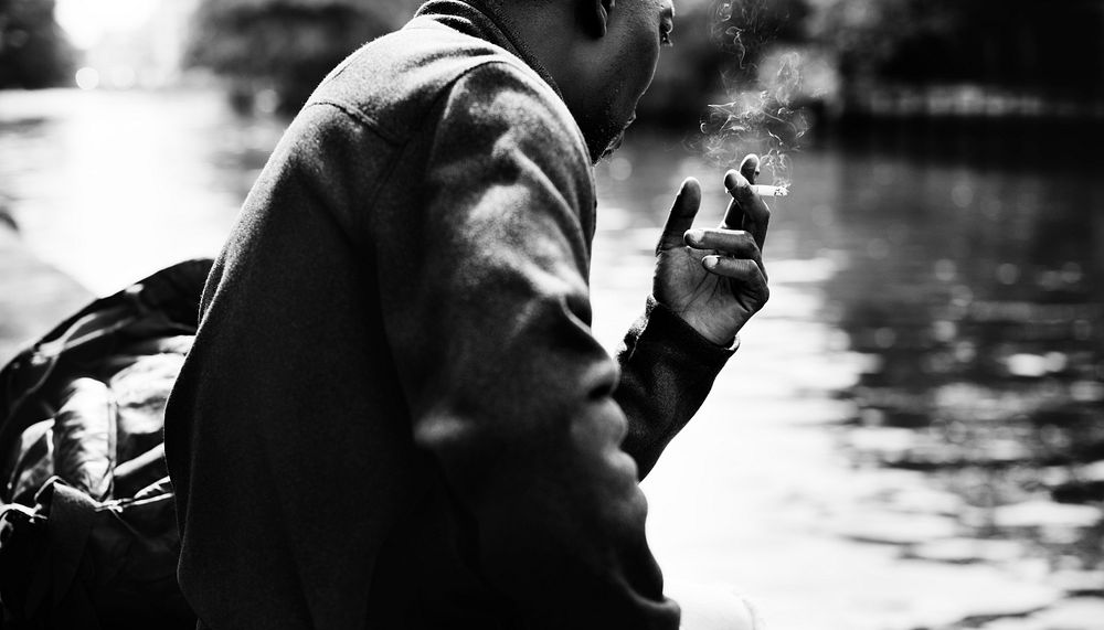 Man smoking a cigarette by the water