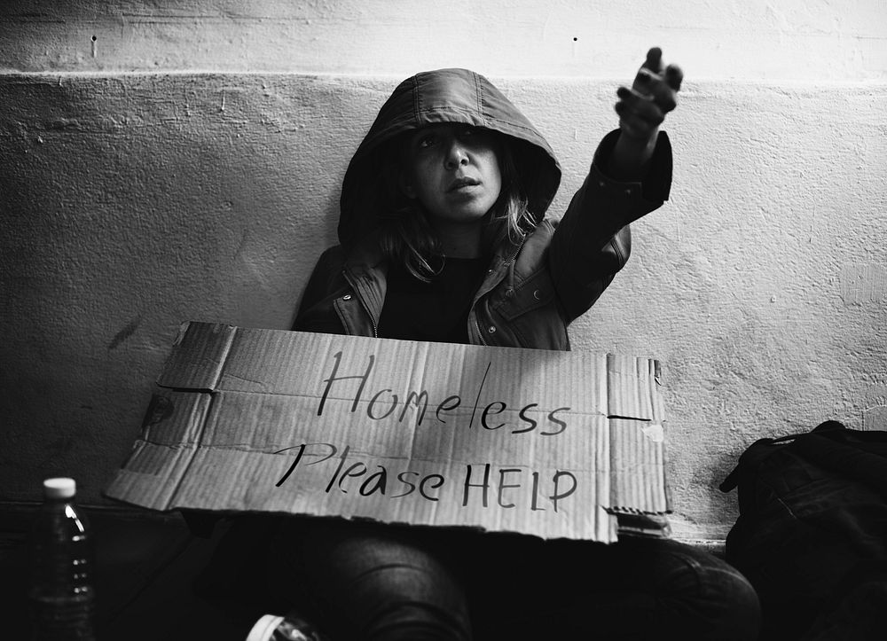 Homeless woman with a please help sign