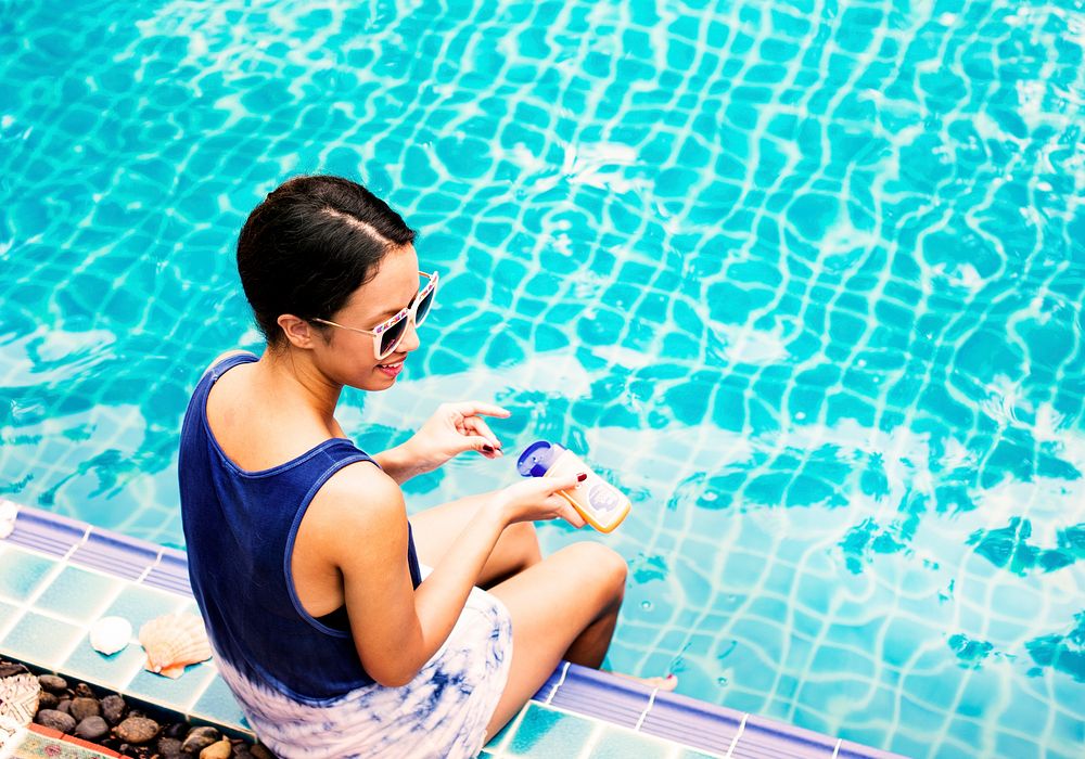 Asian woman sitting by the pool