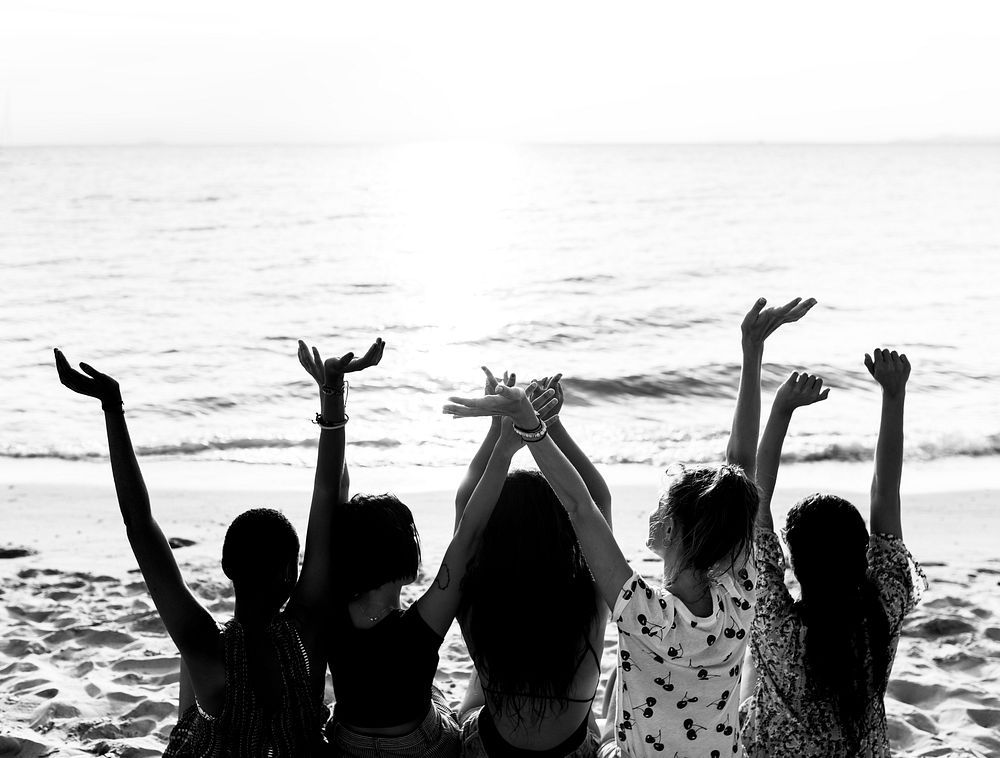 Group of diverse women sitting at the beach together