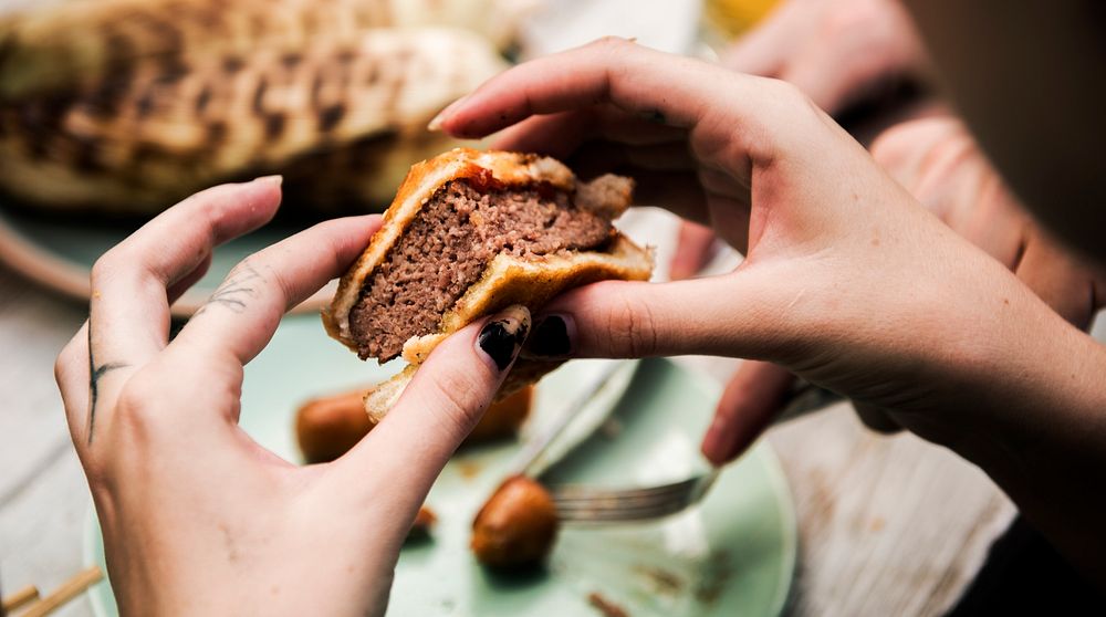 Clsoeup of hands holding bite burger