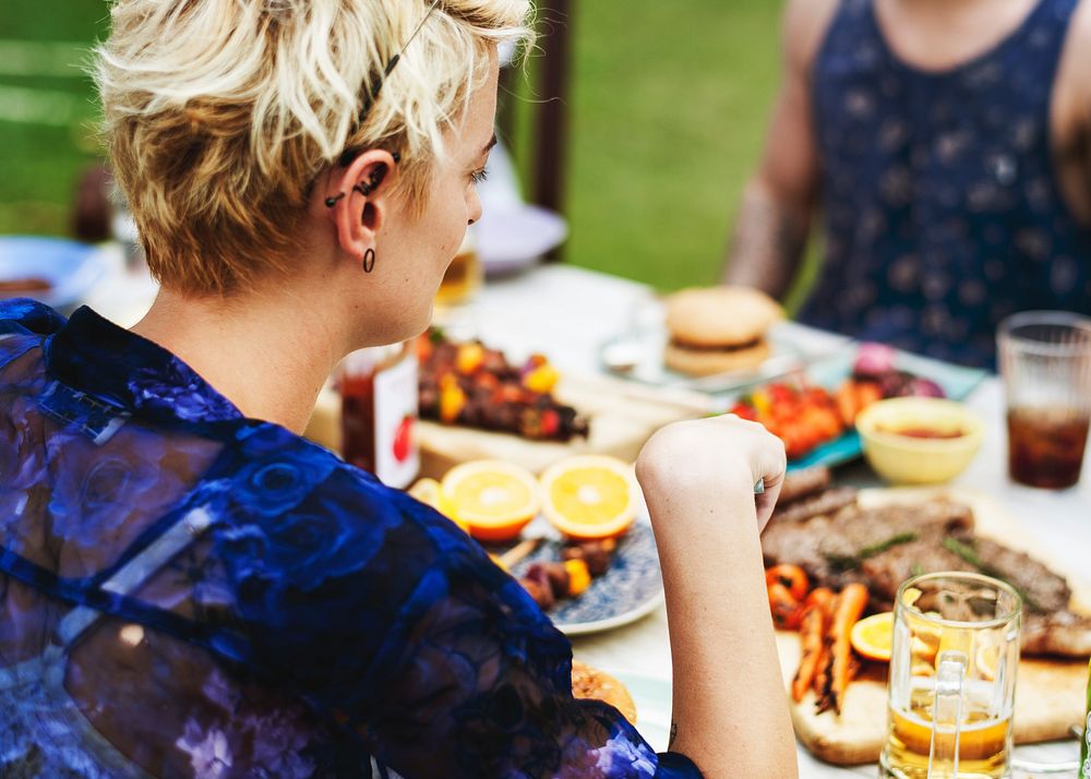 Group of friends having food in the yard