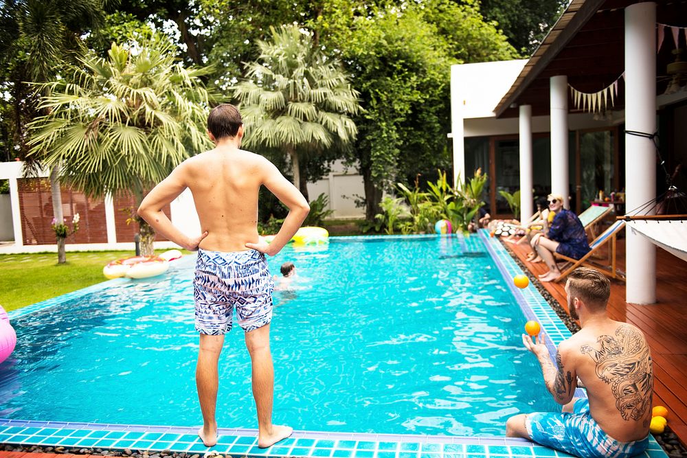 Rear view of man standing by the pool