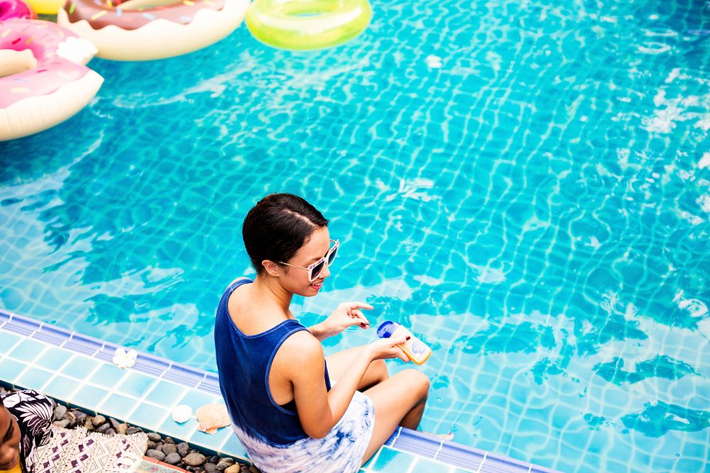Asian woman sitting by the pool