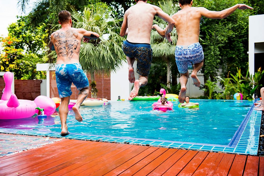 Group of diverse men jumping to the pool