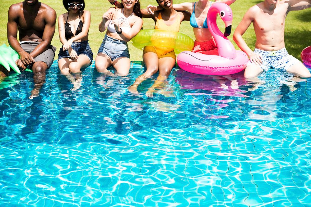 Group of diverse friends enjoying the pool with inflatable tubes