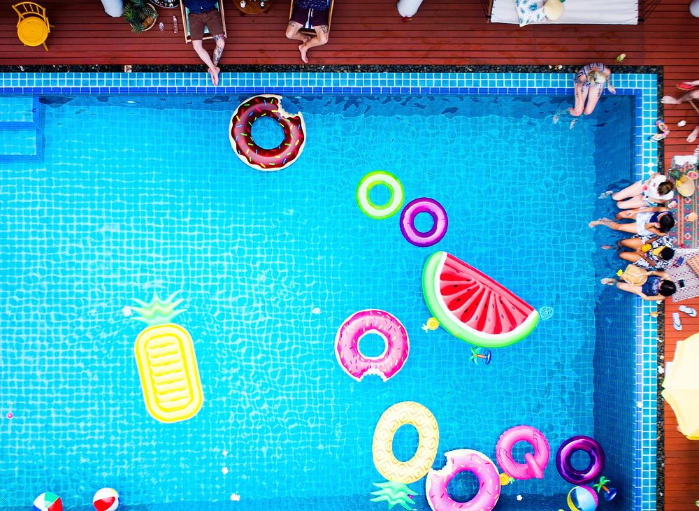 Aerial view of people enjoying the pool with colorful inflatable floats