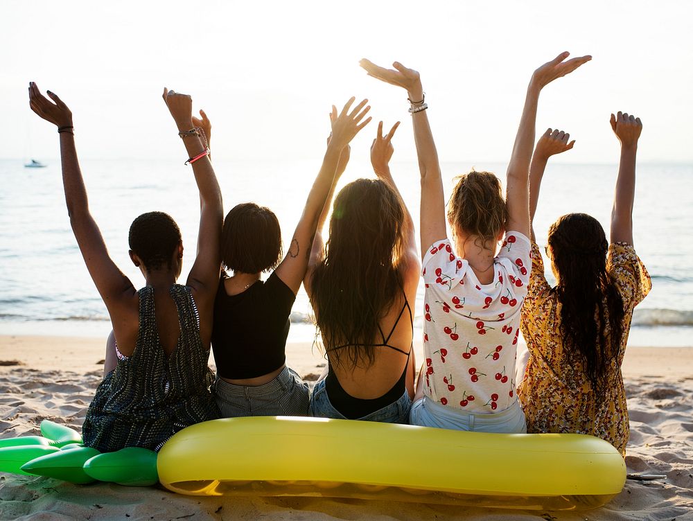 Group of diverse women sitting at the beach together