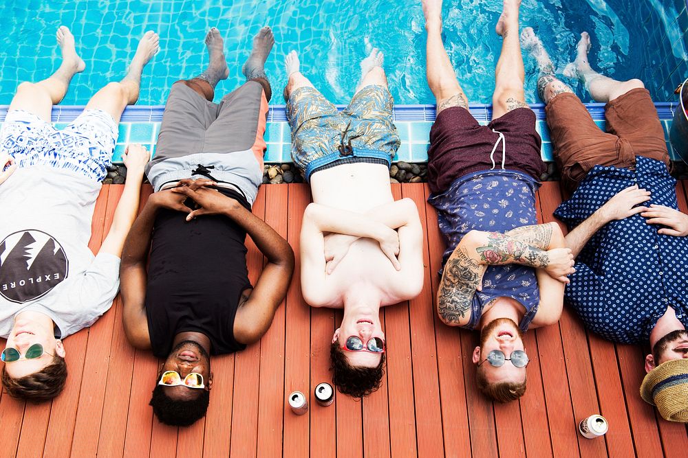 Group of diverse men put their legs in the pool