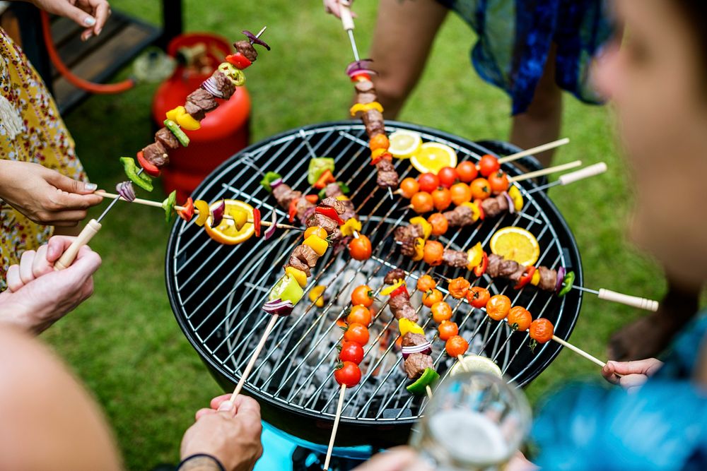 Aerial view of a group of diverse friends grilling barbecue outdoors 