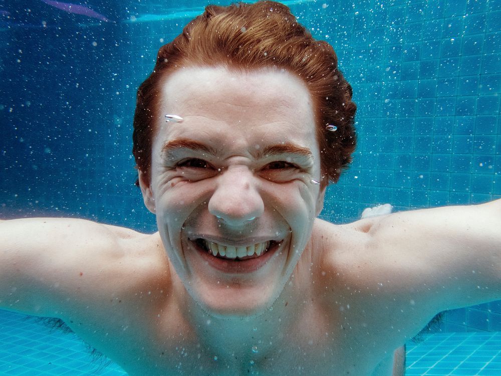 A caucasian man smiling underwater 