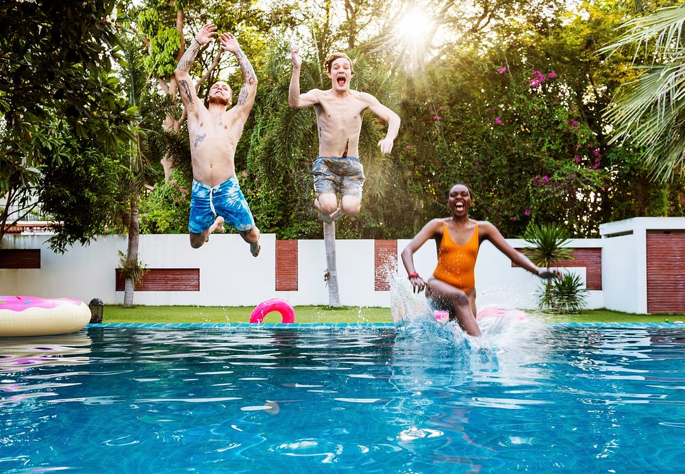 Group of diverse jumping to the pool enjoying summer time