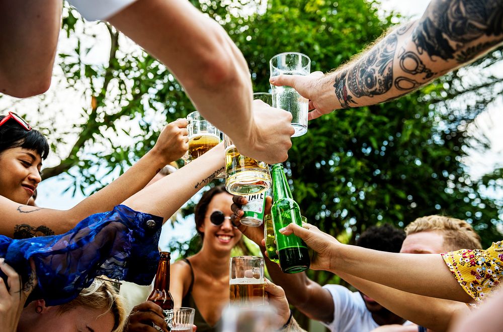 Group of diverse friends celebrating drinking beers together