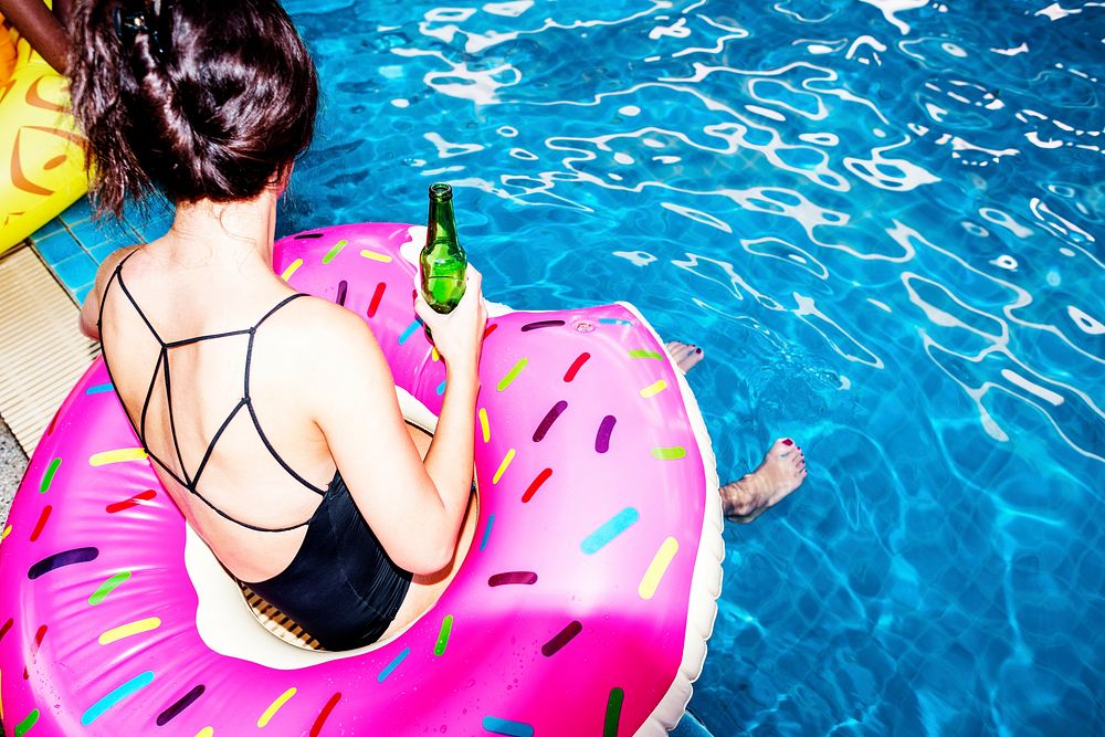 Asian woman sitting by the pool with beverage
