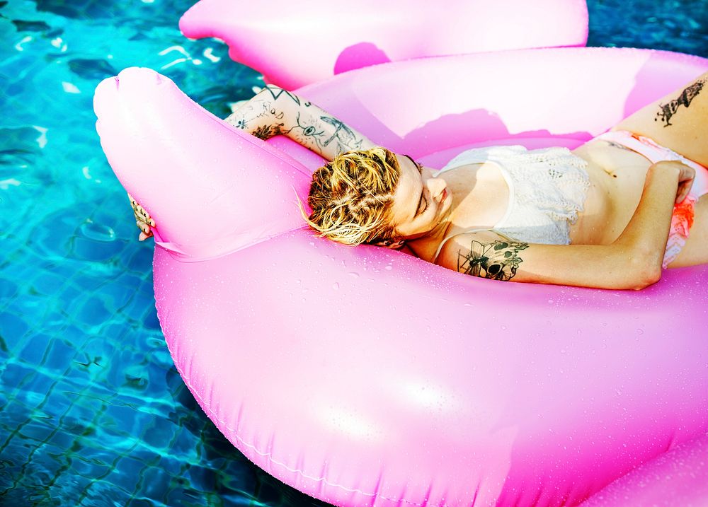 A closeup of a Caucasian woman floating in the pool on an inflatable float
